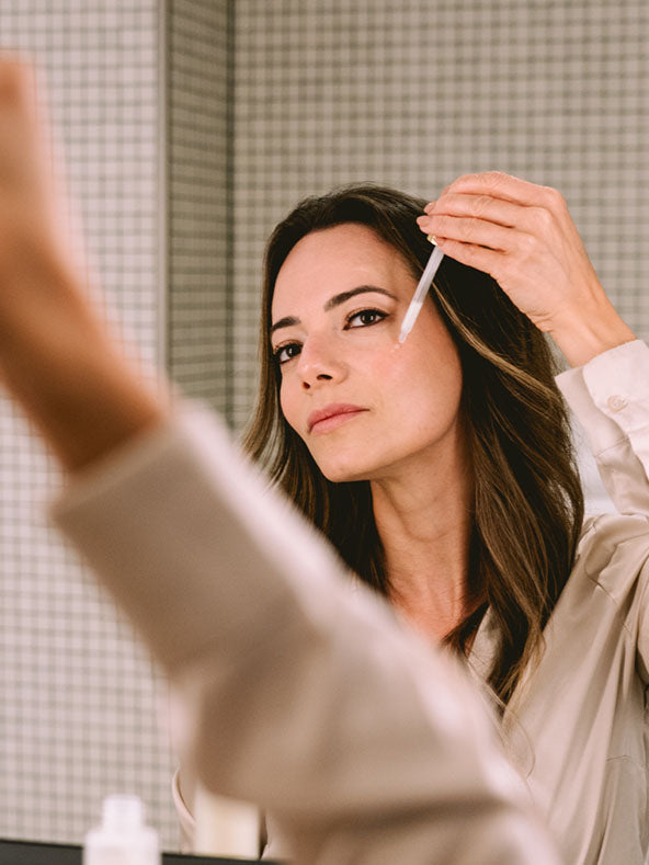 Frau trägt Feuchtigkeitsspendendes Gesichtsserum auf ihr Gesicht auf