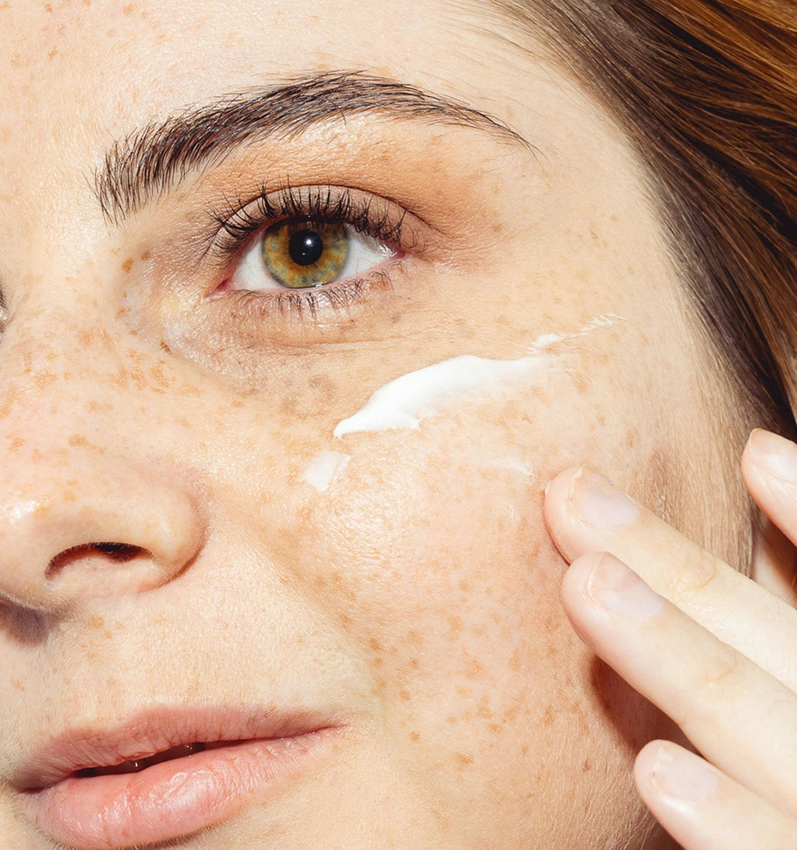Eine Frau trägt Feuchtigkeitsspendende Tagescreme auf