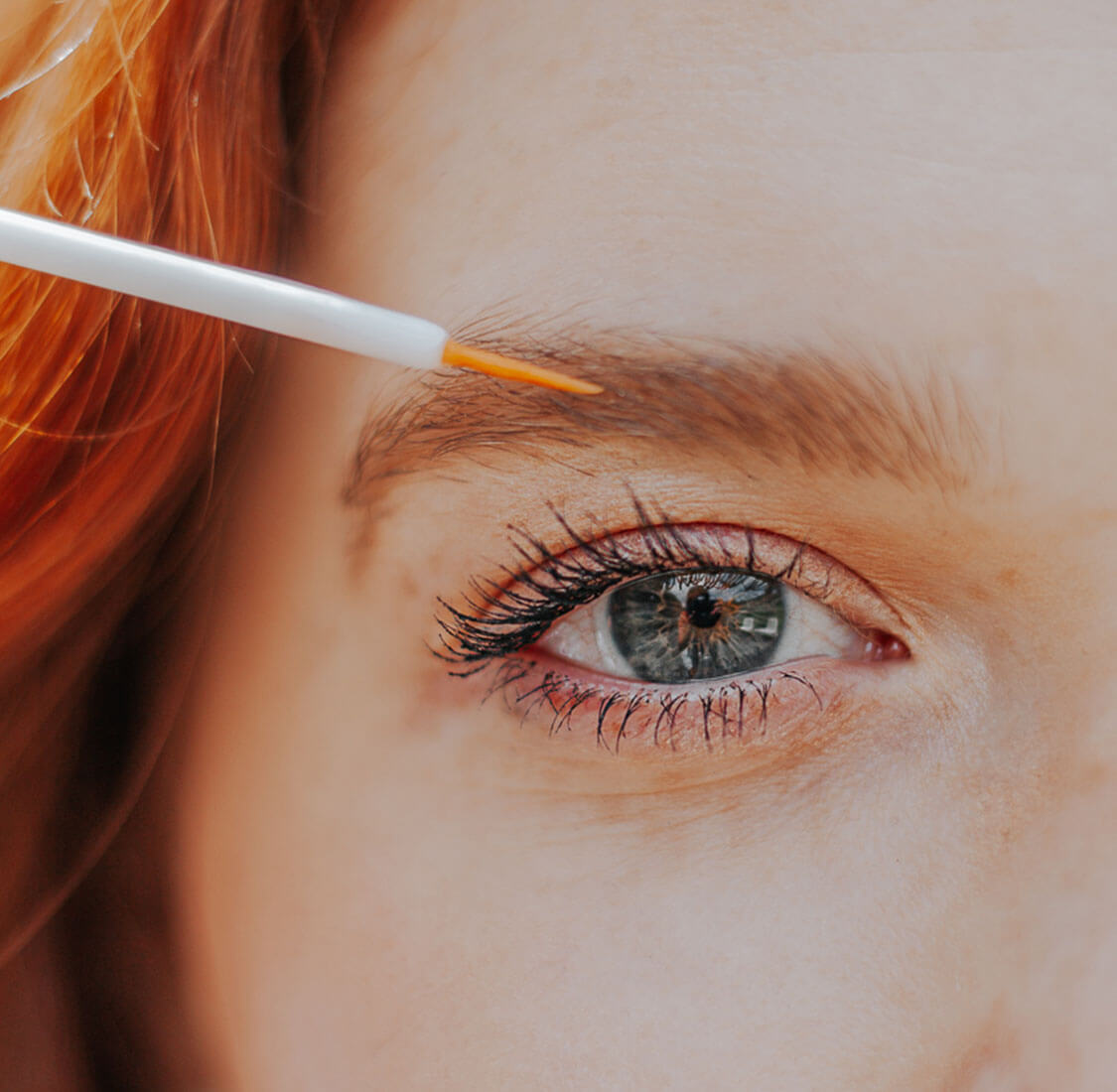 Frau die Stärkendes Wimpernserum aufträgt
