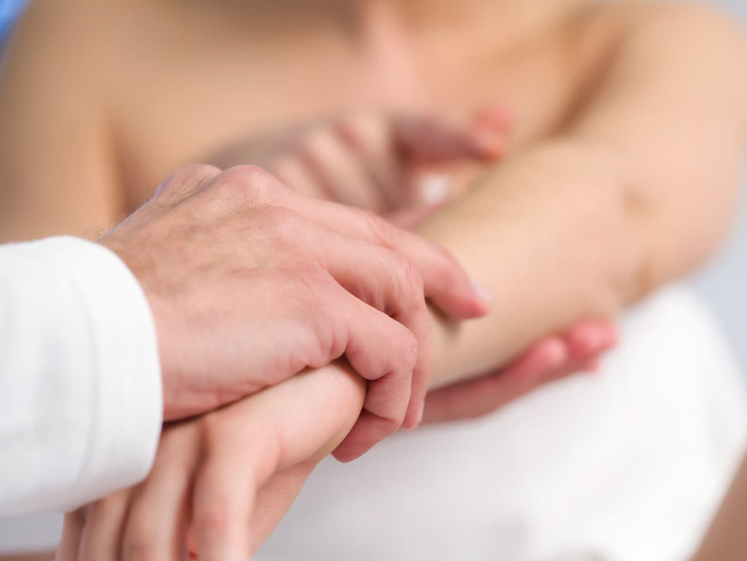 Doktor die die hand eines Patienten hält