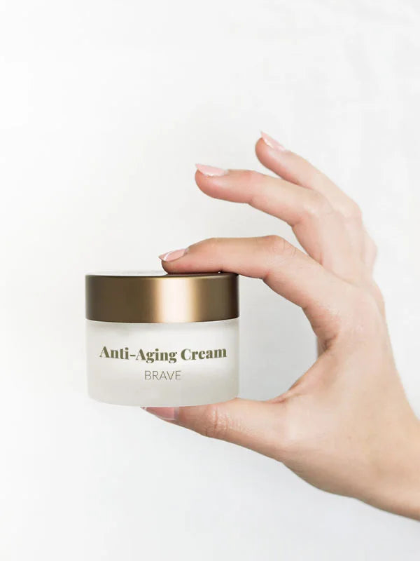 Frauenhände halten eine Dose des Revitalisierende Anti-Aging Creme mit CBD.