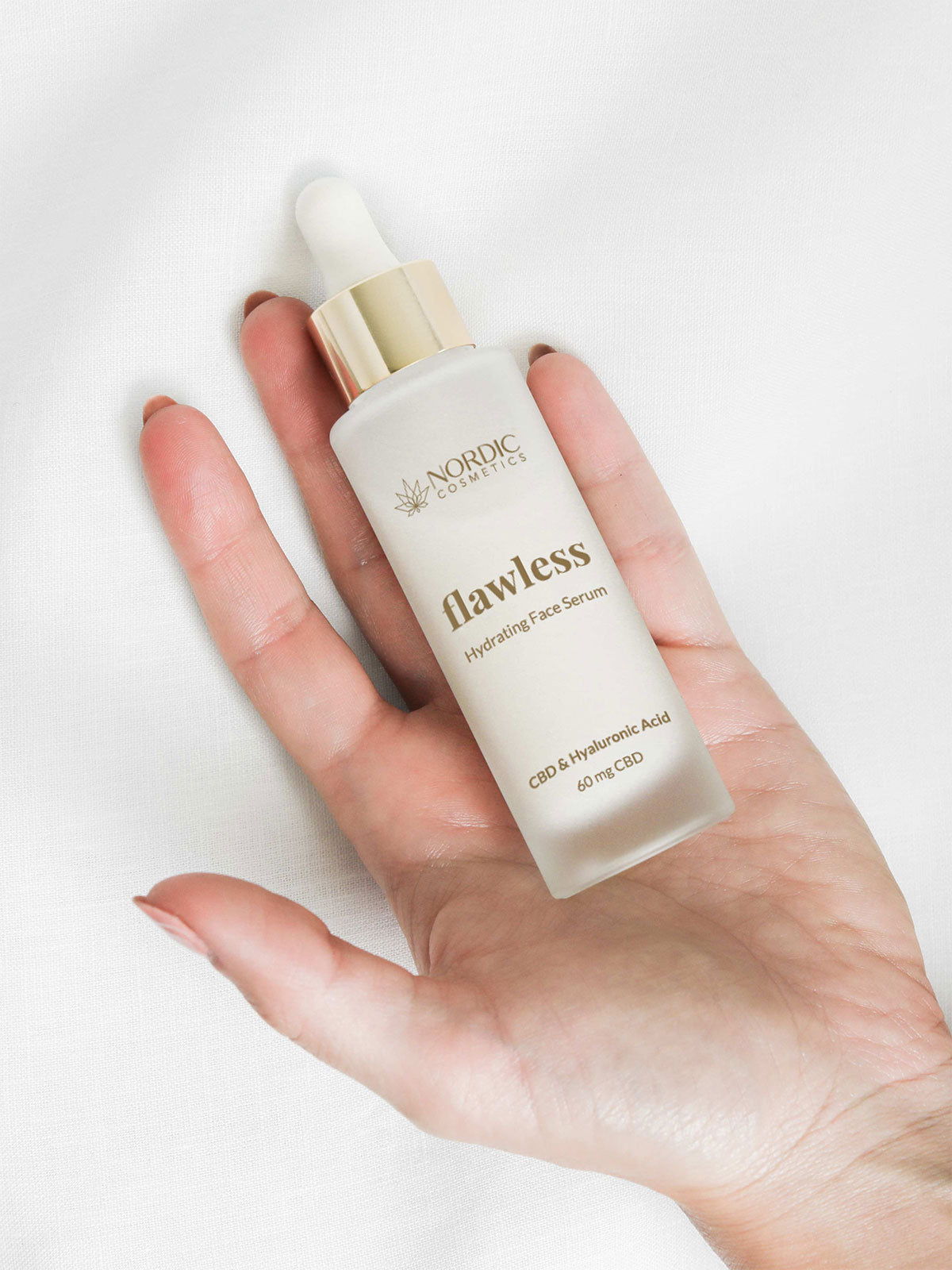 Auf einer Frauenhand liegt eine Flasche des Nordic Cosmetics Feuchtigkeitsspendendes Gesichtsserum