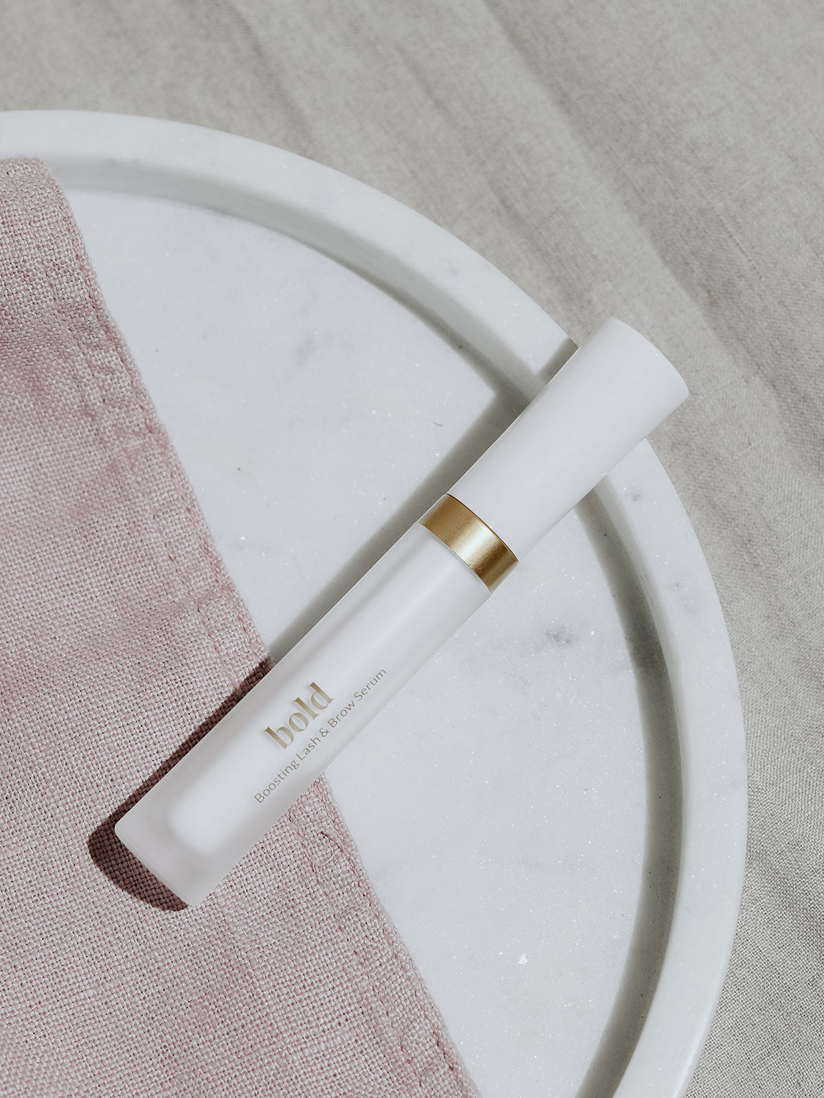 Stärkendes Wimpernserum liegt auf einer Marmor Platte