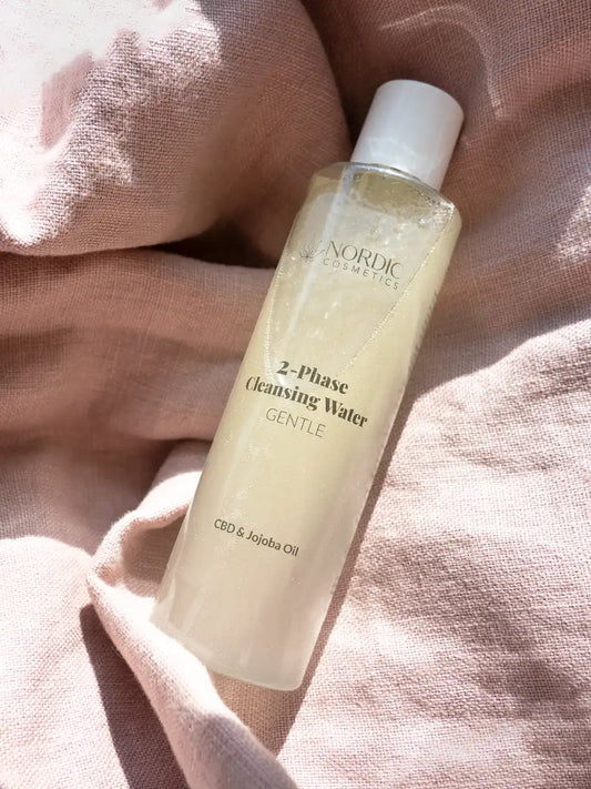 2-Phase Cleansing Wasser mit CBD und Jojoba Oil von Nordic Cosmetics auf rosa Stoff
