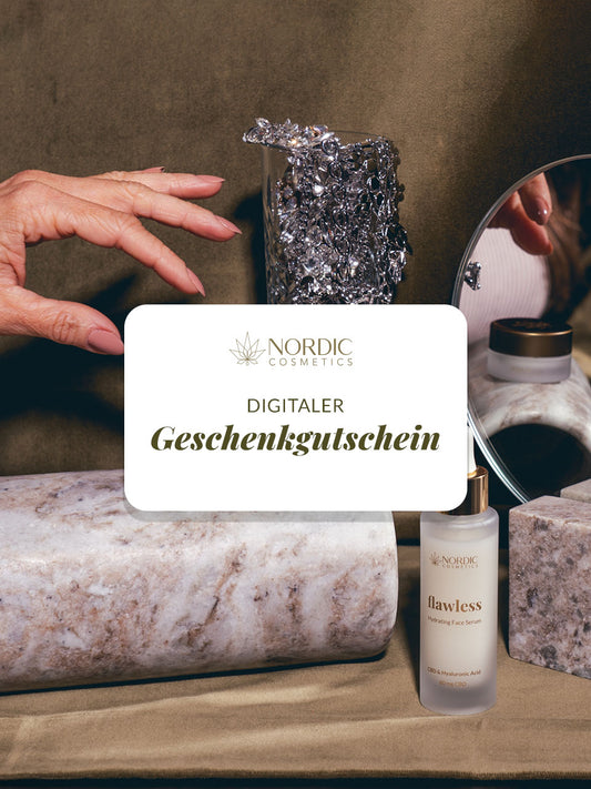 Das Bild zeigt eine Anzeige von Nordic Cosmetics mit einem digitalen Geschenkgutschein. Im Vordergrund sind Marmorsteine und eine Flasche "flawless" Hydrating Face Serum zu sehen. Eine Hand, ein Spiegel und ein Glas mit Glitzersteinen sind dekorativ im Hintergrund platziert.