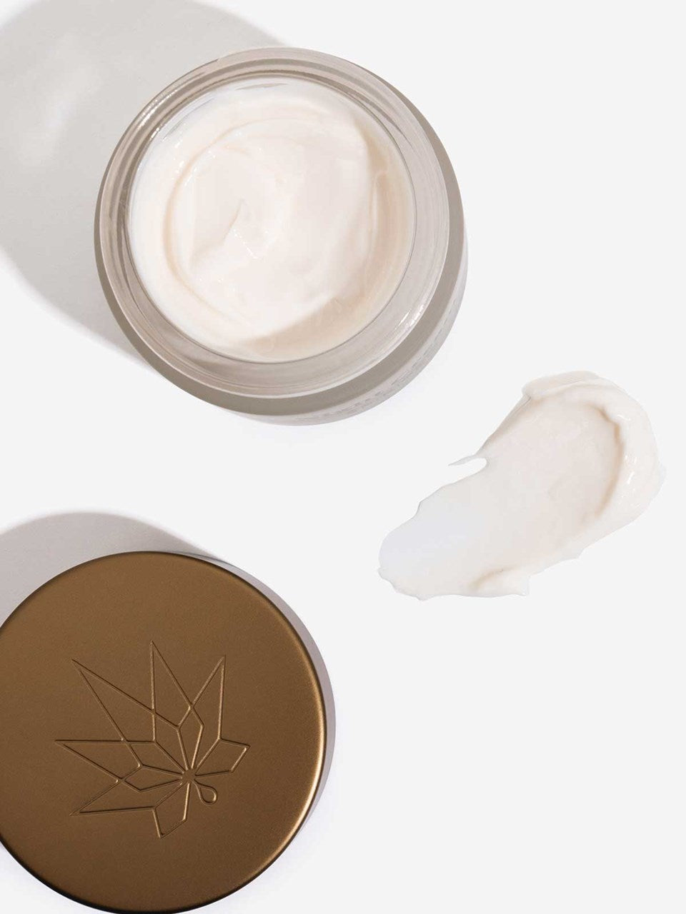 Die Revitalisierende Anti-Aging Creme steh offen auf dem Bild daneben ein Fleck der Creme