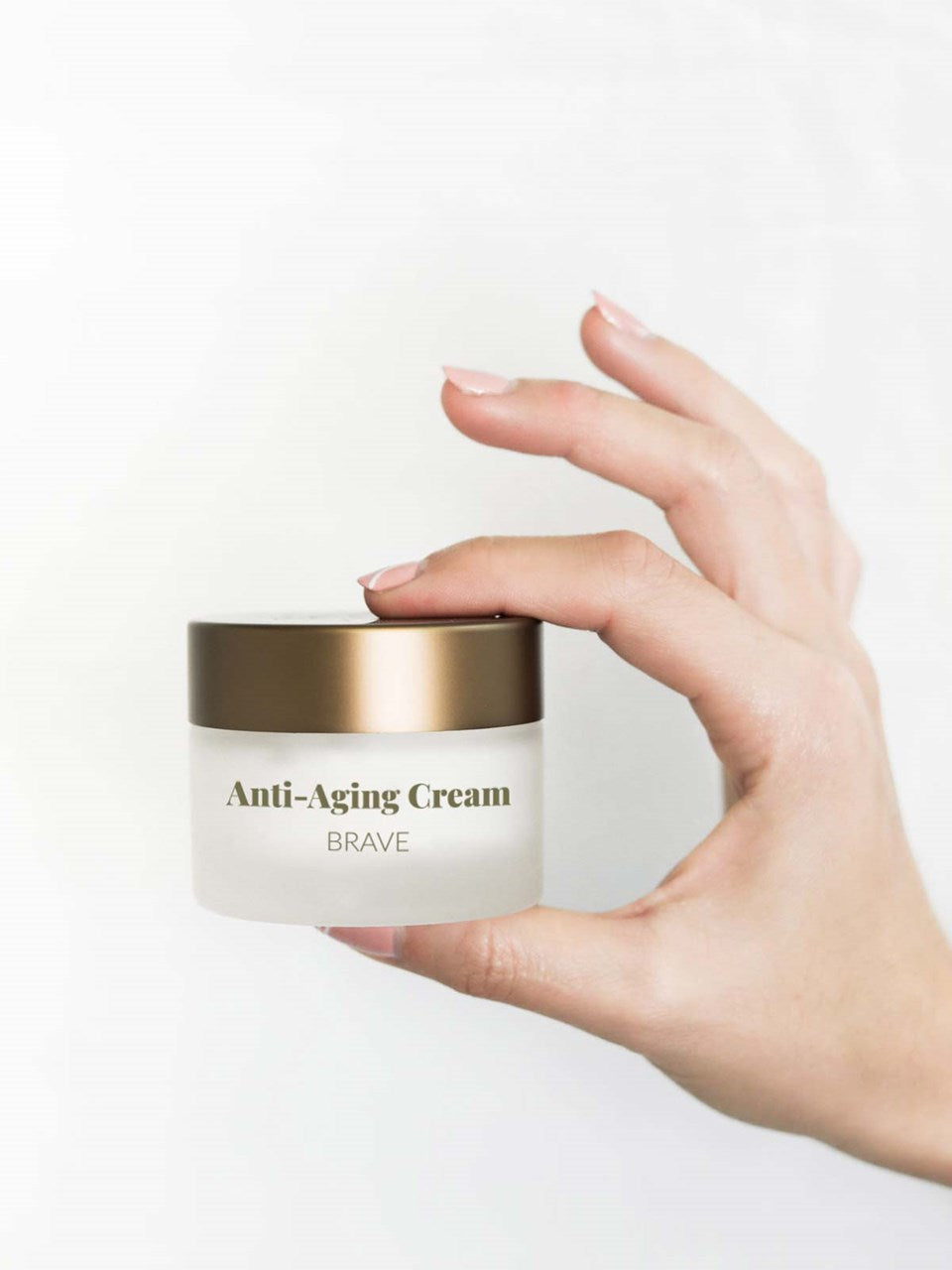 Frauenhände halten eine Dose des Revitalisierende Anti-Aging Creme mit CBD.