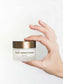 Frauenhände halten eine Dose des Revitalisierende Anti-Aging Creme mit CBD.